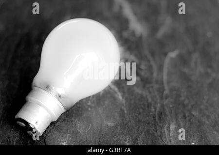Glühbirne auf Schiefer grau hinterlegt Stockfoto