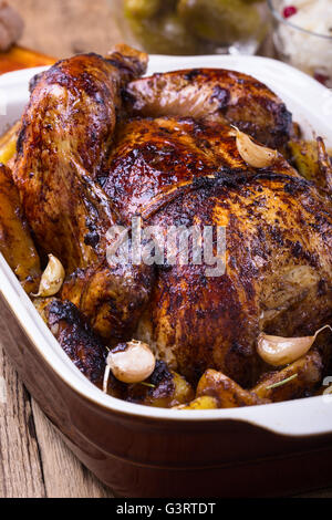 Hausgemachte ganz gebratenes Huhn mit Knoblauch und Kartoffeln in keramischen Pfanne Stockfoto