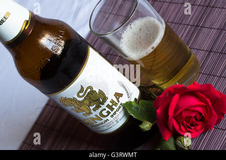 Abstrakte Sicht auf eine kalte Flasche Thai Bier, Singha, teilweise in ein Glas genommen in Durham, England gegossen. Stockfoto