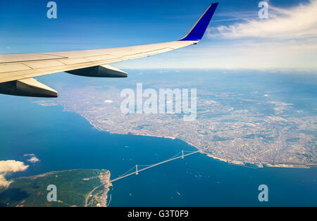 Fliegen über Japan, die Akashi-Kaikyo-Brücke durch ein Flugzeugfenster gesehen Stockfoto