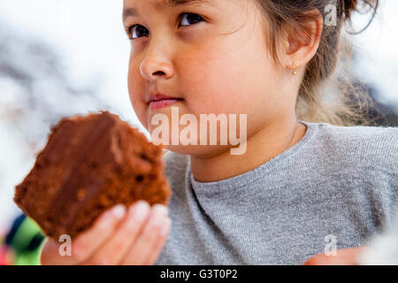 Kleines Kind essen ein Stück Schokoladenkuchen, Maresfield, Sussex, UK Stockfoto