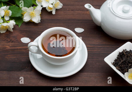 Tee mit Jasminblüten auf einem braunen Holztisch Stockfoto