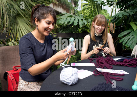 Stricken Hilfe nehmen Teil an einer Veranstaltung für Flüchtlinge und Migration, stricken Quadrate, die in Decken für Flüchtlinge genäht werden. Stockfoto