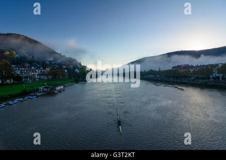 Neckar bei Sonnenaufgang und Morgen Nebel mit einem Ruderboot, mit Blick auf die Altstadt und auf dem Königsstuhl, Deutschland, Baden-Württembe Stockfoto