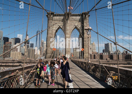 Eine Schulgruppe auf der Brooklyn Bridge mit New York City im Hintergrund, USA 2016 Stockfoto