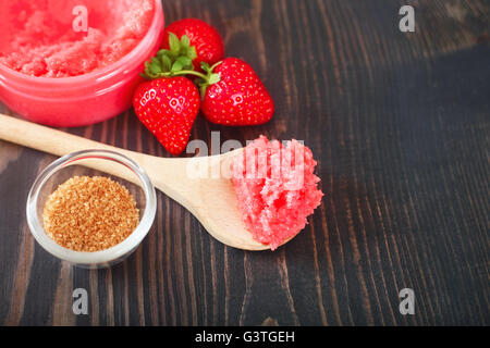 Erdbeer-Körperpeeling mit braunem Zucker auf dem hölzernen Hintergrund Stockfoto