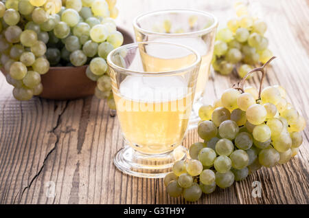 Frischen Weintrauben und frisch gepressten Traubensaft Saft auf rustikalen Holztisch, Erntezeit Stockfoto
