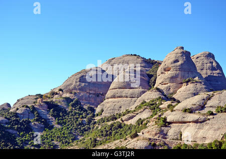 Berge von Montserrat, Katalonien, Spanien, und kleine steinerne Kapelle von Sant Joan am Berghang Stockfoto