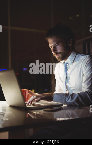 Geschäftsmann mit Laptop in der Nacht Stockfoto