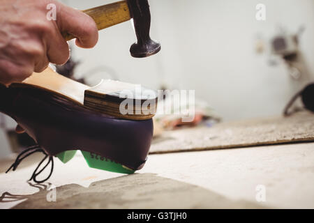 Nahaufnahme von Hand Hämmern auf der Ferse des Schuhs Stockfoto