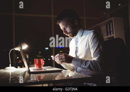 Geschäftsmann mit Smartphone in der Nacht Stockfoto