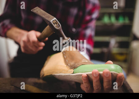 Nahaufnahme von Hand Hämmern auf einen Schuh Stockfoto