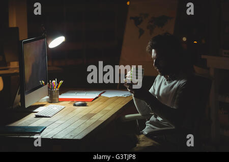 Geschäftsmann mit seinem Smartphone in der Nacht Stockfoto