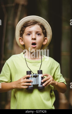 Kleiner Junge hält Fernglas und schockiert Ausdruck Stockfoto