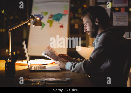 Geschäftsmann Lesung Dokumente in der Nacht Stockfoto