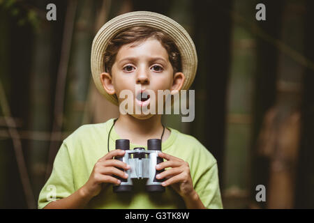 Kleiner Junge hält Fernglas und schockiert Ausdruck Stockfoto