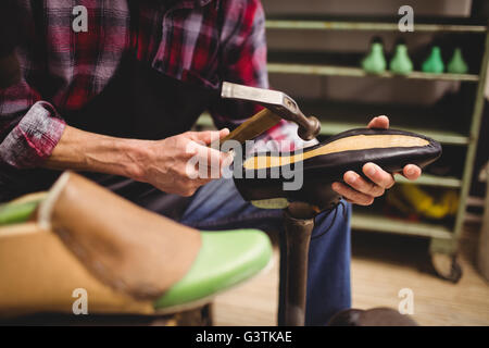 Nahaufnahme von Hand Hämmern auf einen Schuh Stockfoto