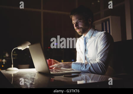 Geschäftsmann mit Laptop in der Nacht Stockfoto