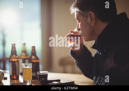 Reifer Mann trinken von Alkohol Stockfoto