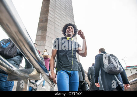 Ein junger Mann, anhören von Musik über Kopfhörer auf der South Bank in London. Stockfoto