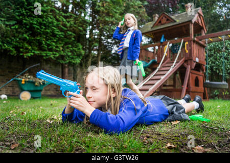 02:10 Jahre alten Mädchen in der Schule einheitliche Holding Wasserpistolen. Stockfoto