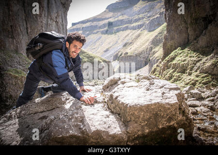 Ein Bergsteiger klettern über die Felsen in unwegsamem Gelände. Stockfoto