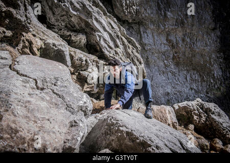 Ein Bergsteiger klettern über die Felsen in unwegsamem Gelände. Stockfoto