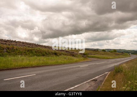 Die B6282 Straße in Middleton in Teesdale im Nordosten von England zeigen die urbares Land und dunkle Vorahnung Himmel Stockfoto