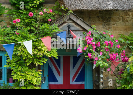 Reetdachhaus und Garten mit Girlanden. Ashton unter Hill, Wychavon Bezirk, Worcestershire, UK Stockfoto