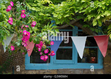 Reetdachhaus Fenster und Rosen und Girlanden. Ashton unter Hill, Wychavon Bezirk, Worcestershire, UK Stockfoto