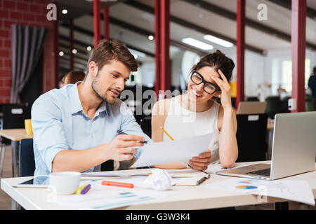 Lächelnde junge Geschäftspartnern zusammenarbeiten im Büro Stockfoto