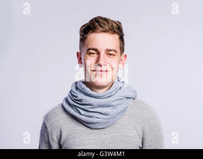 Junge im grauen Pullover und Schal, junger Mann, Studioaufnahme Stockfoto