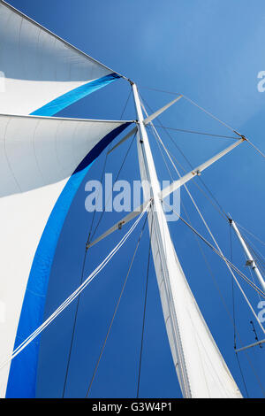 Segeln mit offenen Segeln auf einem Segelboot Mast auf einem blauen Himmel Stockfoto