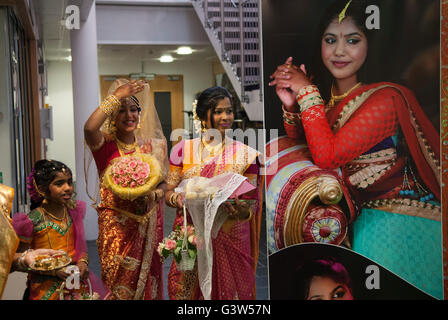 Hindu UK Coming of Age Celebration Party London. Das Foto zeigt die junge Frau. Sie ist auf der linken Seite (mit der Hand angehoben), ihre Mutter auf der rechten Seite. Sie ist 16 Jahre alt. Mitcham Süd-London England. Sie begrüßen Gäste auf der sehr großen Ritushuddhi, auch Ritu Kala Samskara Party genannt. England. Ein fest und der Übergang zur Weiblichkeit. 2010ER JAHRE 2016 UK HOMER SYKES Stockfoto