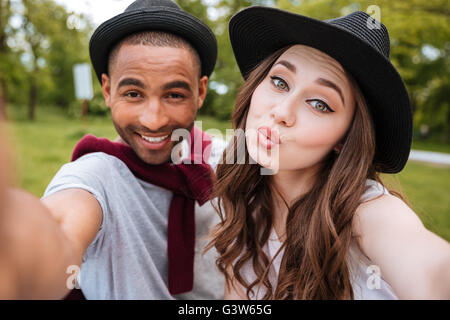 Verspielte junge Brautpaar einen Kuss senden und Selfie im park Stockfoto