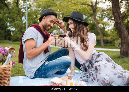 Lächelnde junge Paar Picknick und Weintrinken im freien Stockfoto