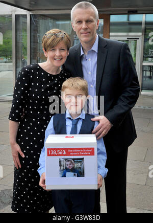 Duchenne-Muskeldystrophie leidenden Michael Young, im Alter von neun, mit seinen Eltern Justin und Michelle, bevor sie erste Minister Nicola Sturgeon an das schottische Parlament in Edinburgh eine Petition vorlegen. Stockfoto