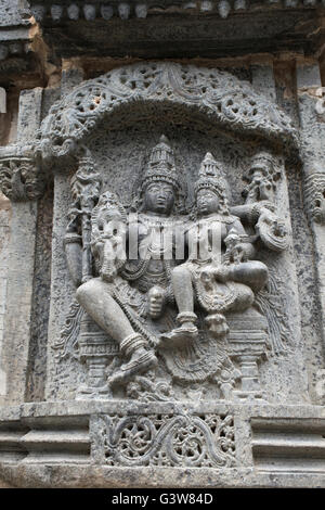 Skulptur Lakshmi sitzen in der Runde von Vishnu. kedareshwara Tempel, halebid, Karnataka, Indien. Nordwand. Stockfoto