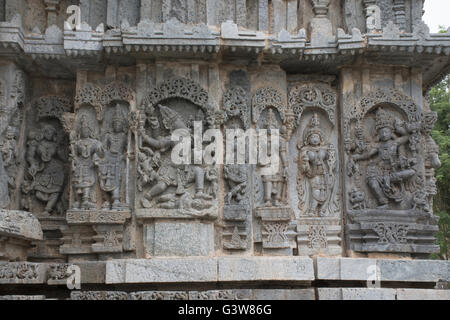 Reich verzierte Bas relieif und Skulpturen der hinduistischen Gottheiten, North East Wall, kedareshwara Tempel, halebid, Karnataka, Indien. Stockfoto