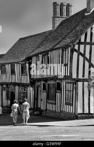 Touristen zu Fuß vorbei an historischen Fachwerkhaus beherbergt, Church Street, Lavenham, Suffolk, UK Stockfoto