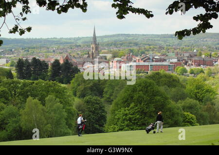 Golfer Kreuz eine grüne auf Tapton Park Golfplatz über Stadtzentrum Chesterfield, Derbyshire, England UK - Frühling Stockfoto