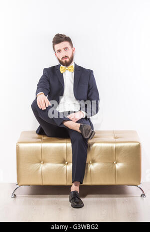Elegante schönen jungen Mann im schwarzen klassischen Anzug mit gelben Fliege Stockfoto