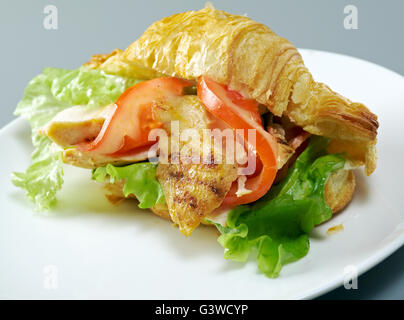 Sommermorgen Frühstück Croissant gefüllt, Hähnchenfilet und Gemüse Stockfoto