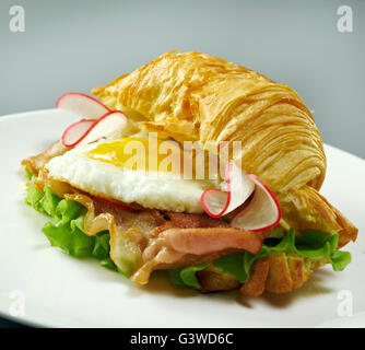 Sommer am Morgen das Frühstück Croissant gefüllt Rührei und Speck gebraten Stockfoto