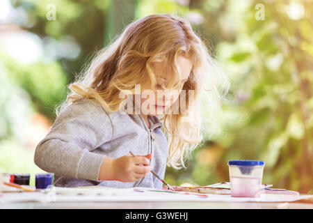 Porträt von kleinen blonden Mädchen malen, im Sommer im Freien. Stockfoto