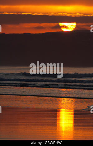 Sonnenuntergang von der nassen Sandstrand reflektiert Stockfoto