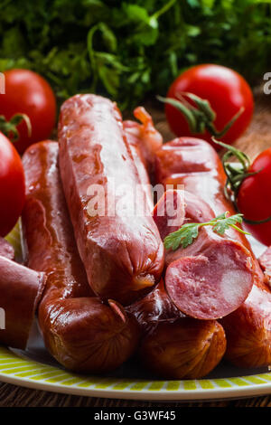 Geräucherte Wurst und rote, reife Tomaten auf dem Küchentisch, selektiven Fokus Stockfoto