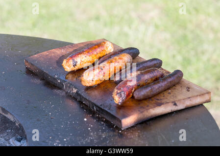 Würstchen auf Cutting Board und Barbecue grill Stockfoto