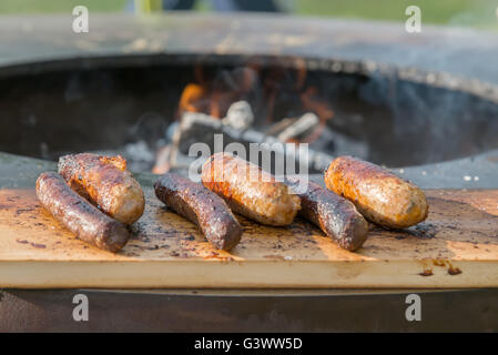 Würstchen auf Cutting Board und Barbecue grill Stockfoto