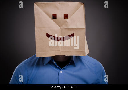 Geschäftsmann mit einem lächelnden Gesicht auf eine Papiertüte denken positives Konzept Bild Stockfoto